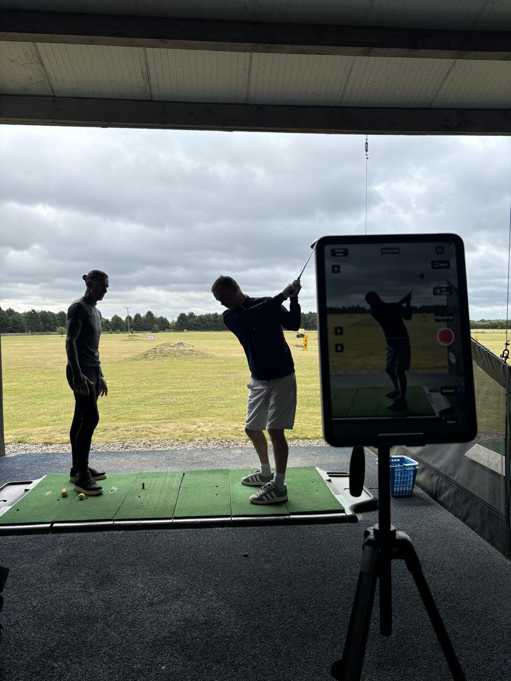Video swing analysis on screen during a golf lesson